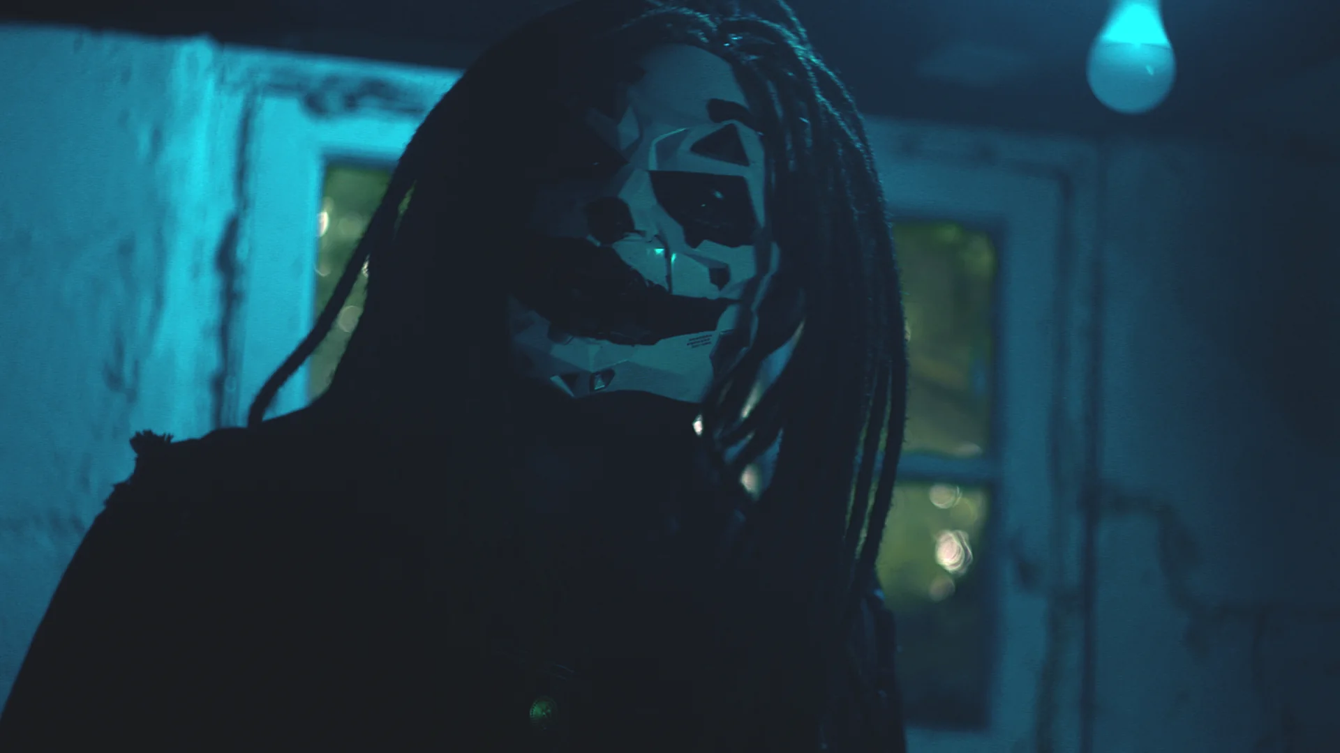 Masked Jai Ghost in a blue-lit basement scene