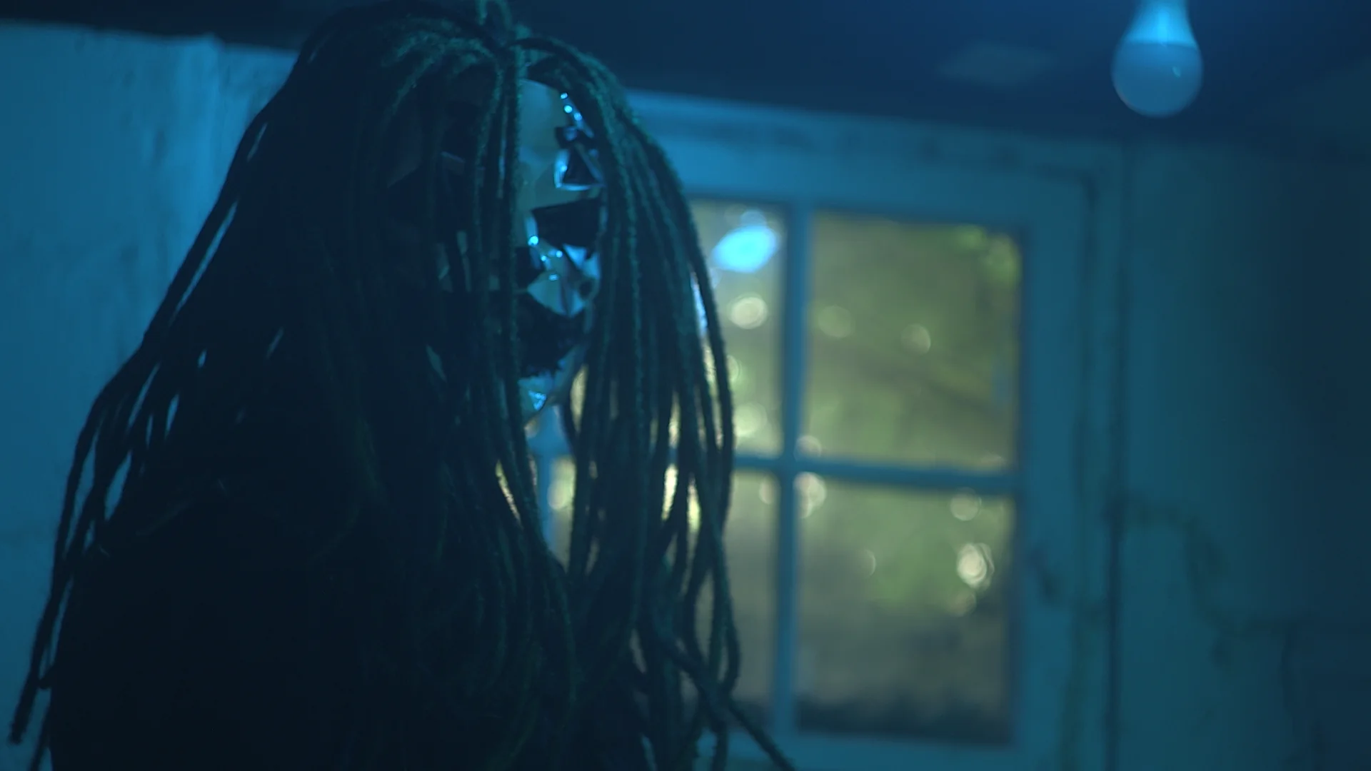 Side portrait of Jai Ghost in the blue-lit basement